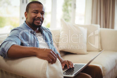 Man using laptop on the couch