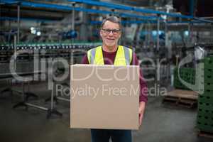 Portrait of factory worker holding cardboard box
