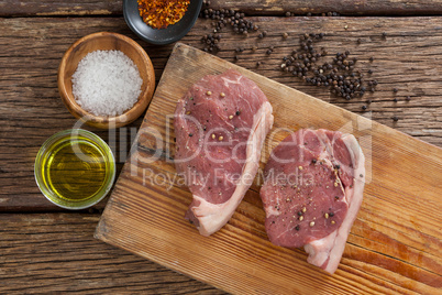Sirloin chops on wooden board with ingredients