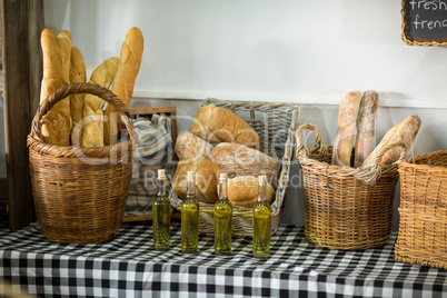 Various bread and bottle of oil on counter in bake shop