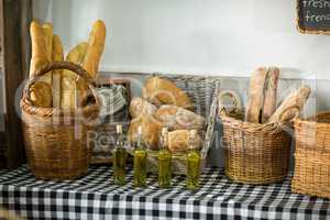 Various bread and bottle of oil on counter in bake shop