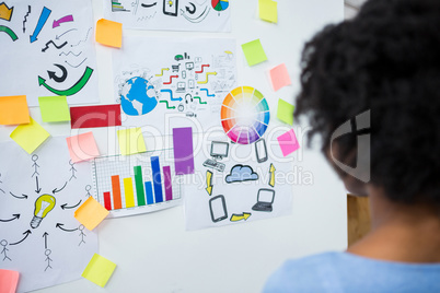 Female graphic designer looking at white board