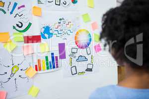 Female graphic designer looking at white board