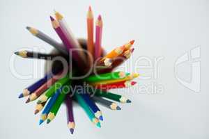 Colored pencils kept in mug on white background