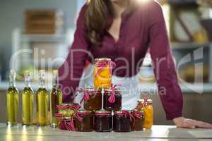 Olive oil, jam, pickle placed together on table