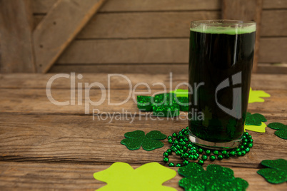 Glass of green beer, beads and shamrock for St Patricks Day
