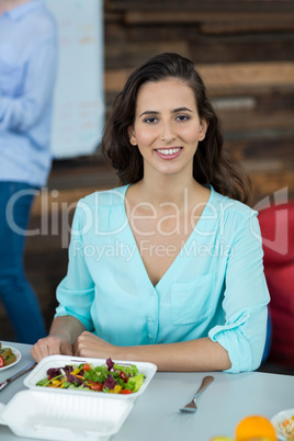 Smiling business executive having meal in office