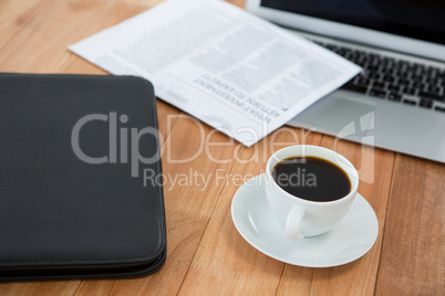 Coffee cup with file folder and laptop