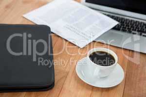 Coffee cup with file folder and laptop