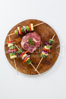 Sirloin chop and skewered vegetables on wooden board