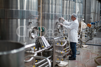 Factory engineer monitoring a pressure gauge of storage tank