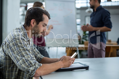 Business executive using mobile phone in a meeting