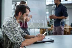 Business executive using mobile phone in a meeting