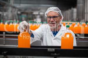 Factory engineer examining a bottle of juice