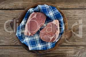 Sirloin chop on wooden tray against wooden background