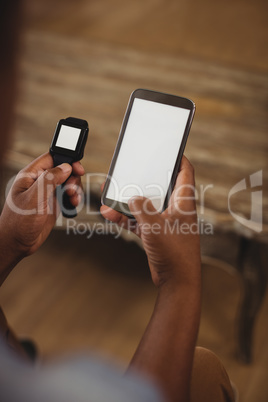 Man using smartwatch and smartphone