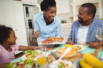 Happy woman serving food to the family