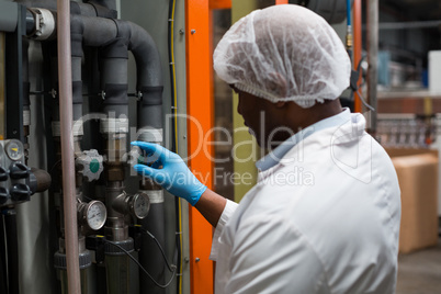 Factory engineer monitoring a pressure gauge in factory