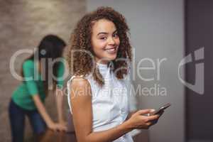 Female executive using mobile phone in office