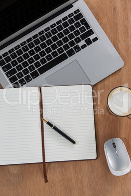 Cup of coffee with laptop, mouse, pen and organizer