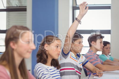 Student raising hand in classroom