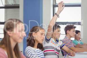 Student raising hand in classroom