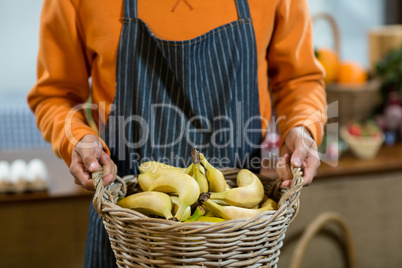 Vendor holding a basket of bananas