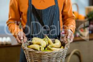 Vendor holding a basket of bananas
