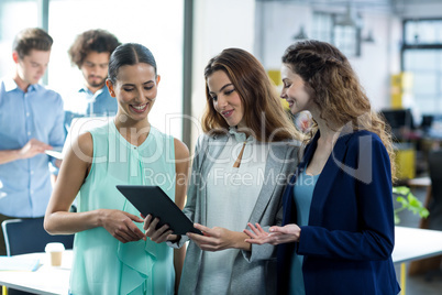Smiling business executives using digital tablet at meeting Smiling business executives using digital tablet at meeting
