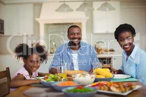 Portrait of family having meal on dinning table at home