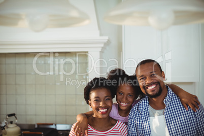 Portrait of happy parents and daughter in kitchen