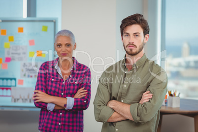 Portrait of business executives standing with arms crossed