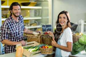Smiling woman interacting with vendor while buying fruits in the grocery store