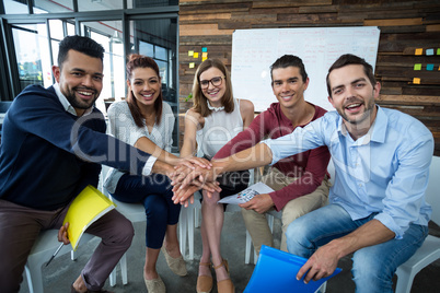 Team of businesspeople forming hand stack in office