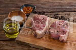 Sirloin chops on wooden board with ingredients