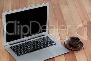 Cup of black coffee and laptop