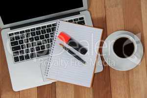 Cup of coffee with laptop, organizer, maker and pen