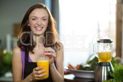 Shop assistant having fresh fruit juice at health grocery shop