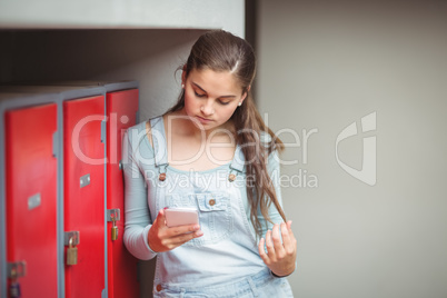 Schoolgirl using mobile phone in locker room