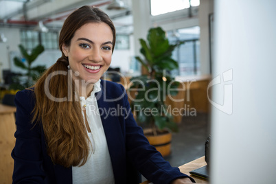 Smiling female executive working on computer