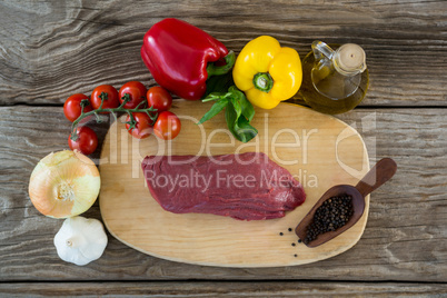 Beef steak and ingredients on wooden tray against wooden background