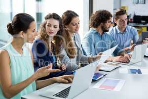 Business team working on laptop and digital tablet in meeting