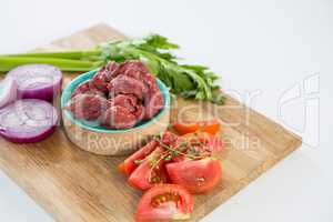 Minced beef and ingredients on wooden tray