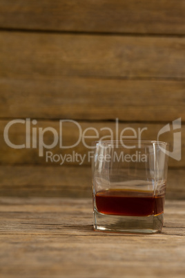 Glass of whisky on wooden table