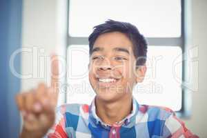 Schoolboy raising hand in classroom