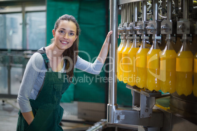 Female factory worker standing near production line