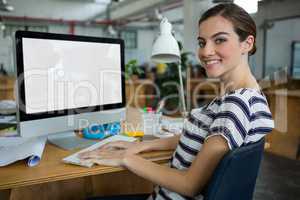 Smiling female graphic designer working on computer