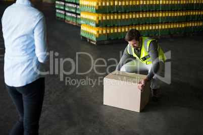 Factory worker picking up cardboard boxes in factory