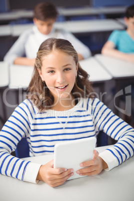 Student holding digital tablet in classroom Student holding digital tablet in classroom
