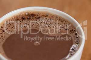 Close-up of white coffee cup with froth